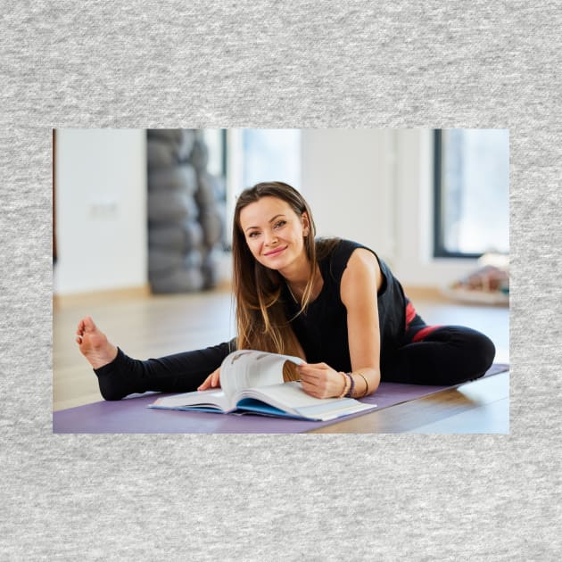 Young woman reading a yoga book by naturalis